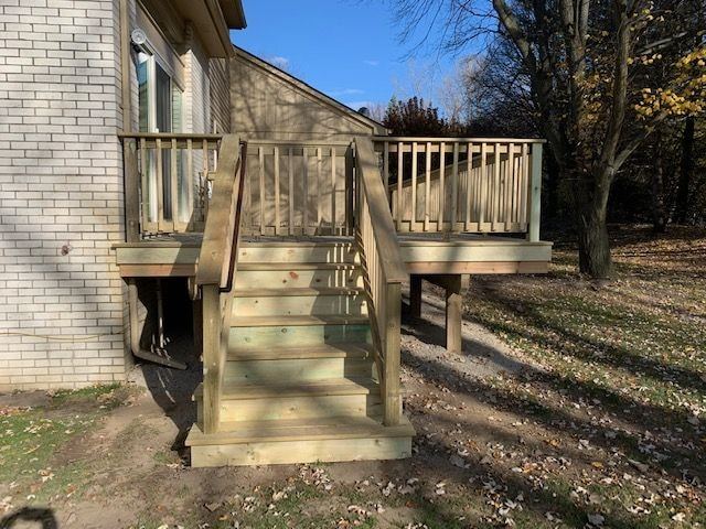 Straight-on view of new pressure-treated wood deck stairs