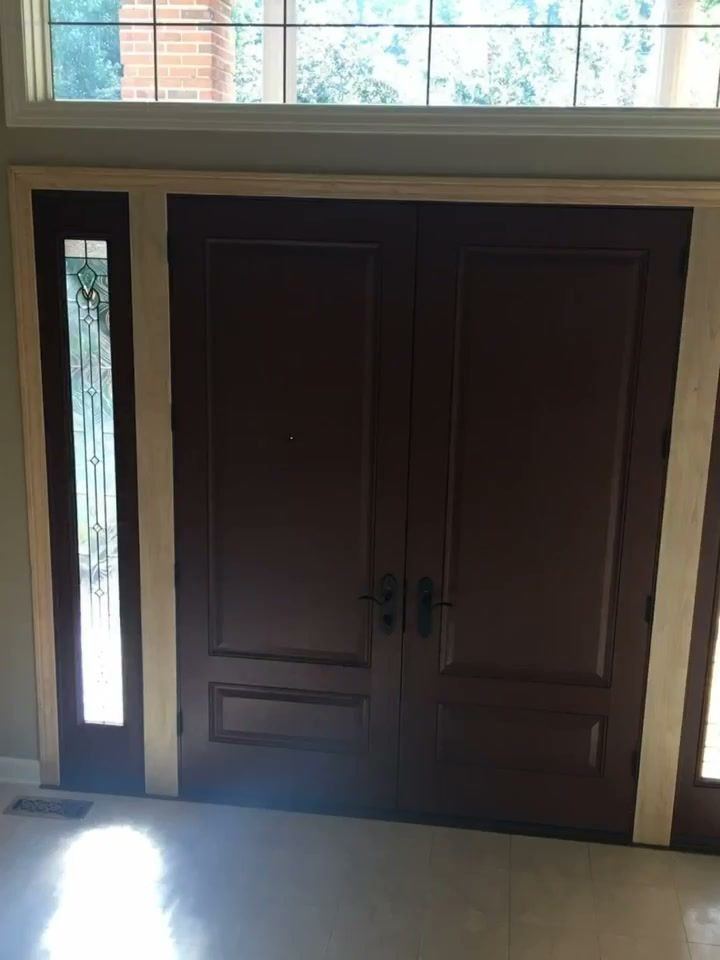 Dark double doors with a leaded decorative sidelight seen from inside, white tile floor